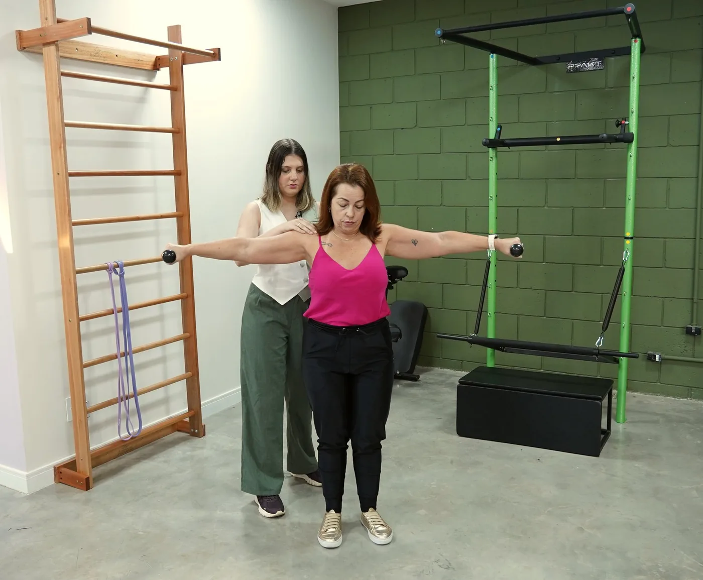 Fisioterapeuta orientando exercício de ombro em paciente no Lyris Wellness Club